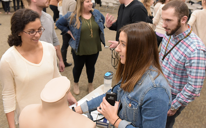 Students practicing medical techniques on a mannequin 